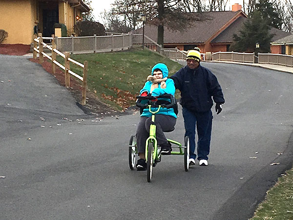 Verland resident riding a bike next to an assistant